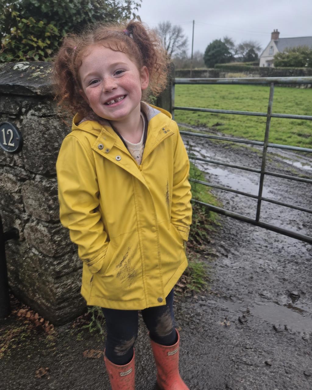 Photo of a freckled girl with curly auburn bunches.