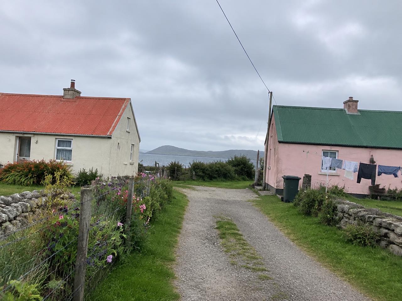 Photo of two cottages along a sandy path