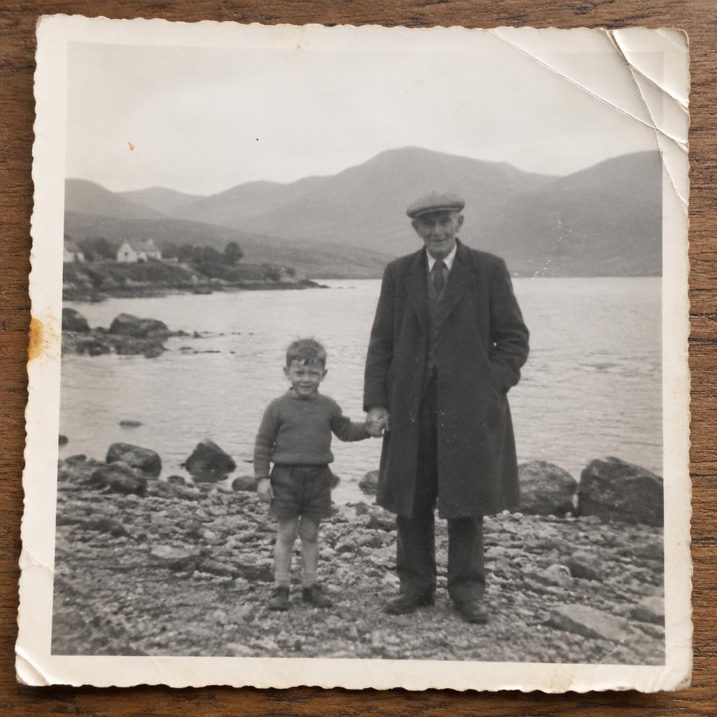 Faded 1958 black-and-white photo of a boy and his grandfather by a lake